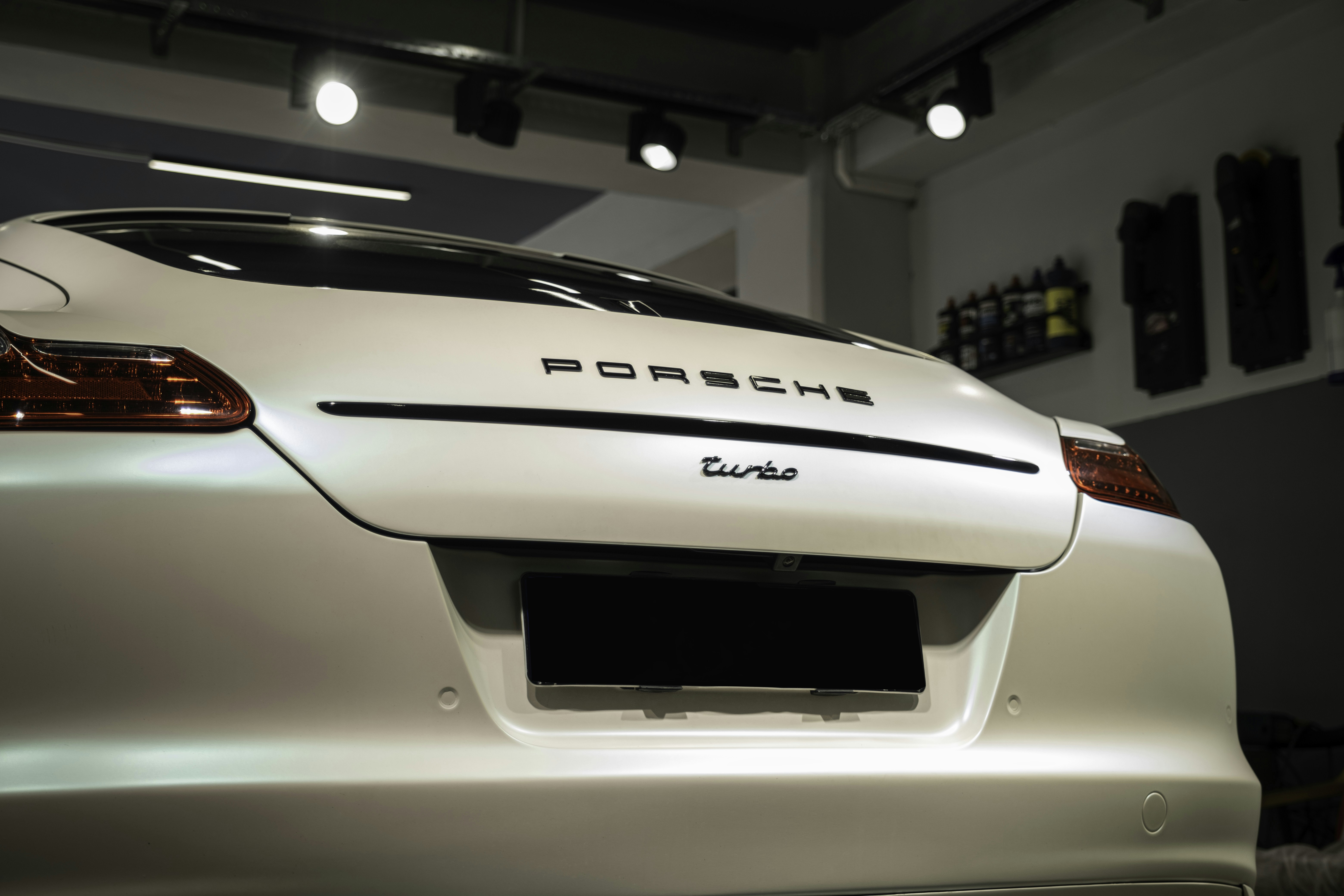 a white porsche car parked in a garage