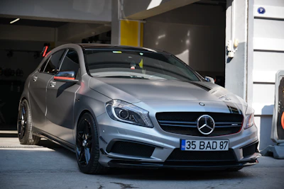 a silver mercedes cla parked in a garage