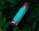 A metal water bottle with a turquoise stripe, featuring a red button on the cap, lies amidst lush, dark green foliage.