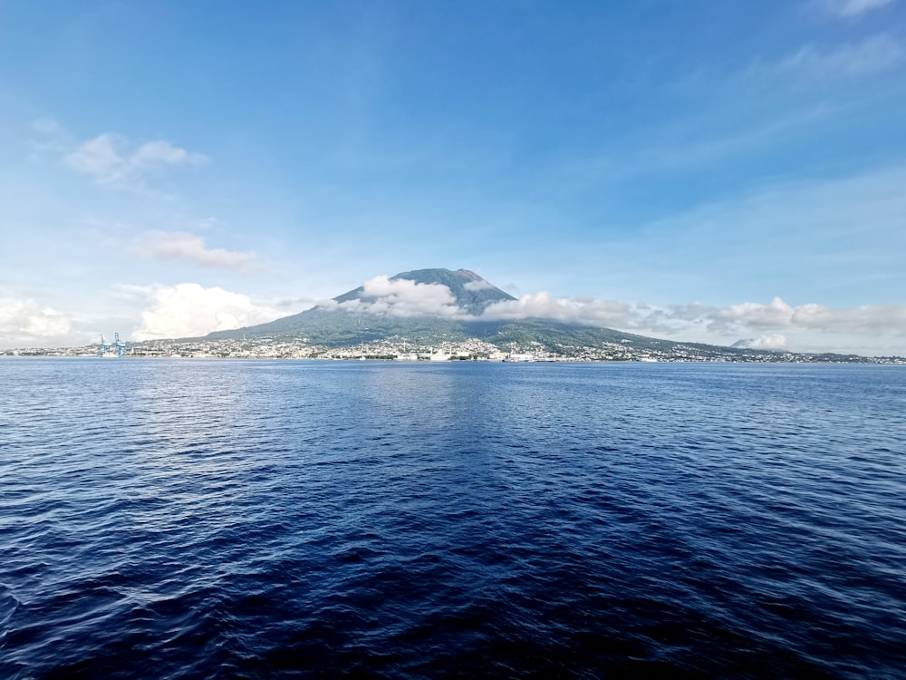 a large body of water with a mountain in the background