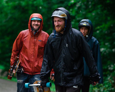 a group of men walking down a road with skateboards