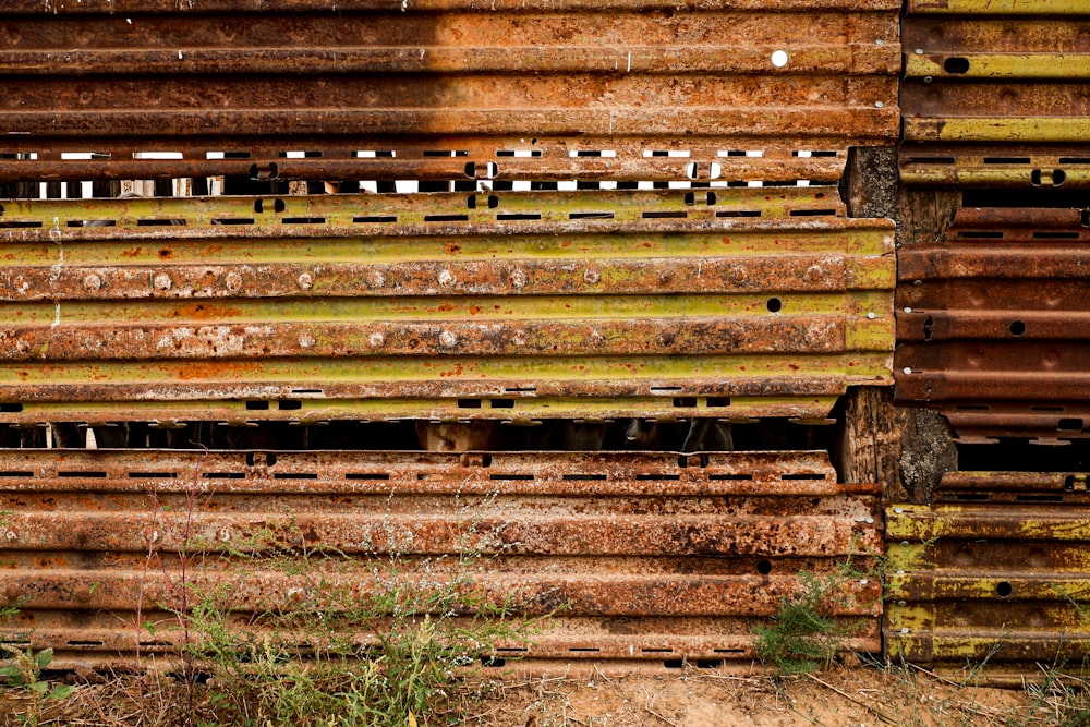 an old rusted metal structure with grass growing out of it