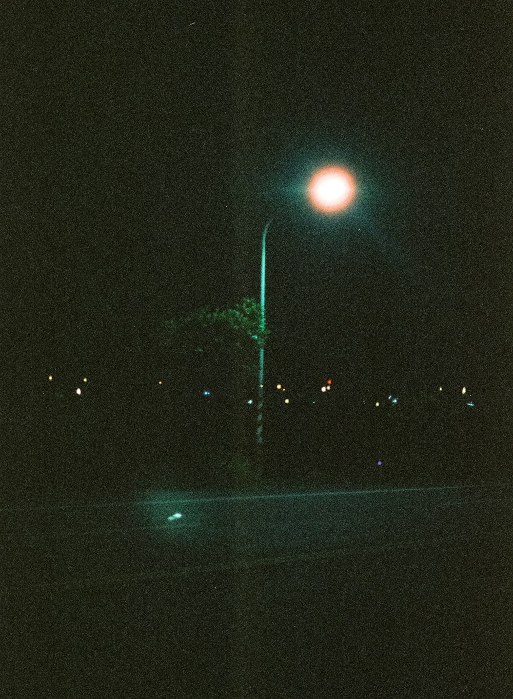 a street light in the dark with a street light in the background