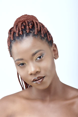 a woman with braids on her hair posing for a picture