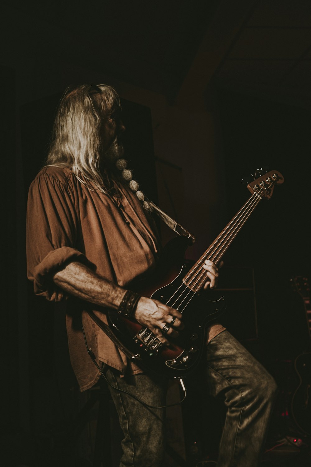 a man with long hair playing a guitar