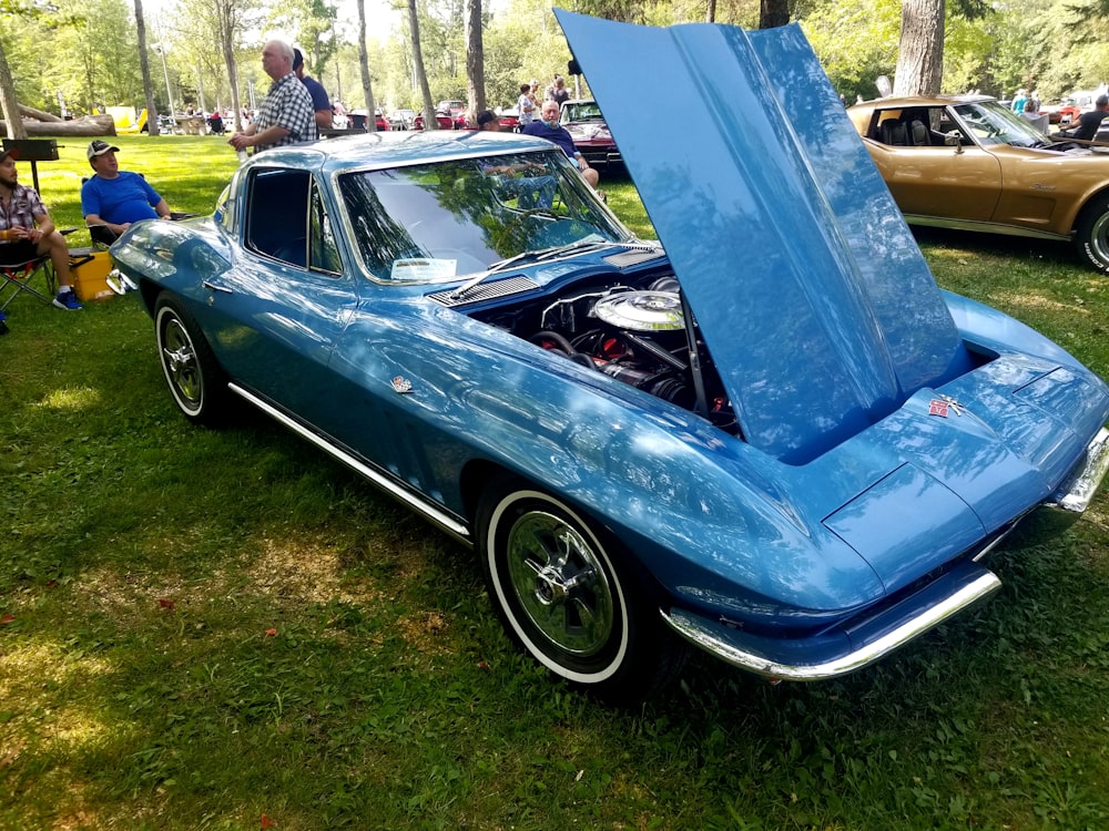 a blue car with its hood open at a car show