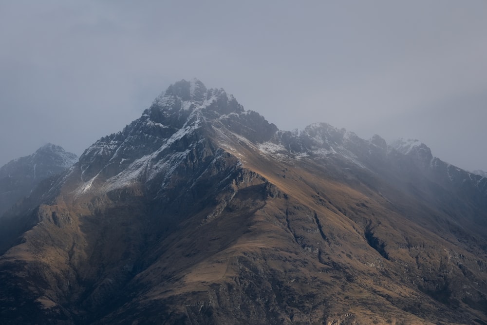 a very tall mountain covered in snow on a cloudy day