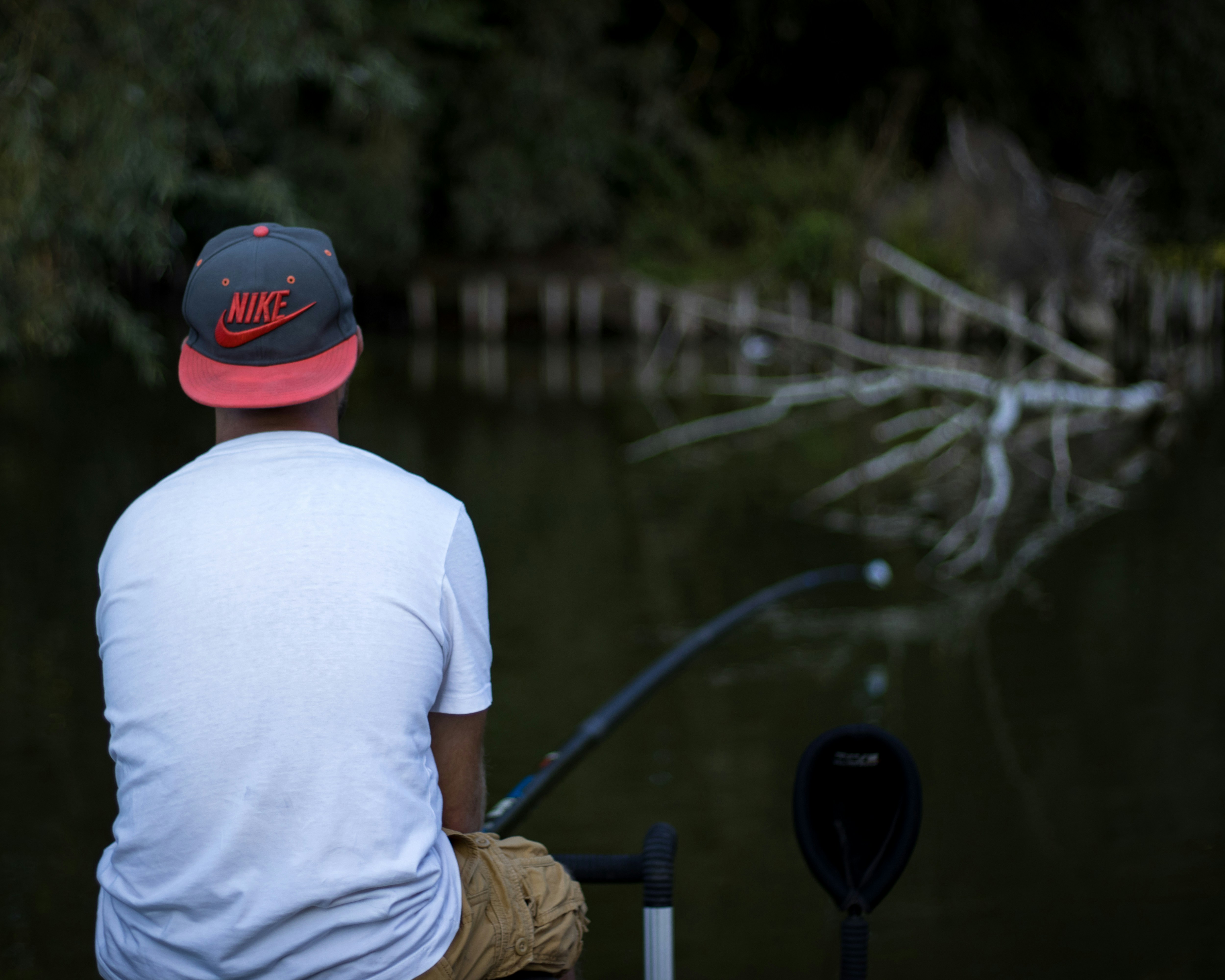a man sitting on a dock with a fishing rod