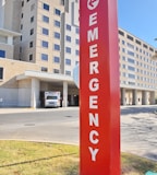 a red emergency sign in front of a large building