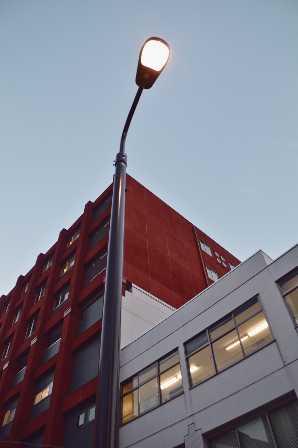 a street light next to a tall red building