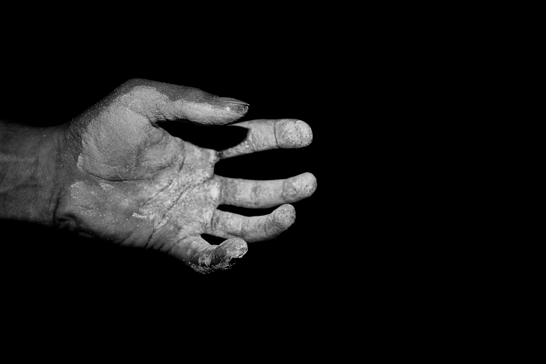 A Chalk-Covered Hand Against A Black Background