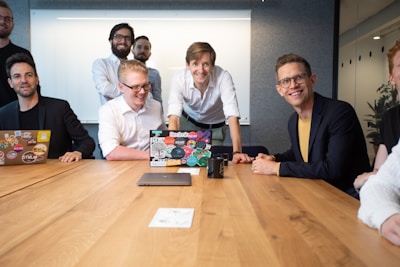 a group of people sitting around a wooden table