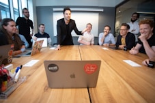 a group of people sitting around a wooden table