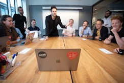 a group of people sitting around a wooden table