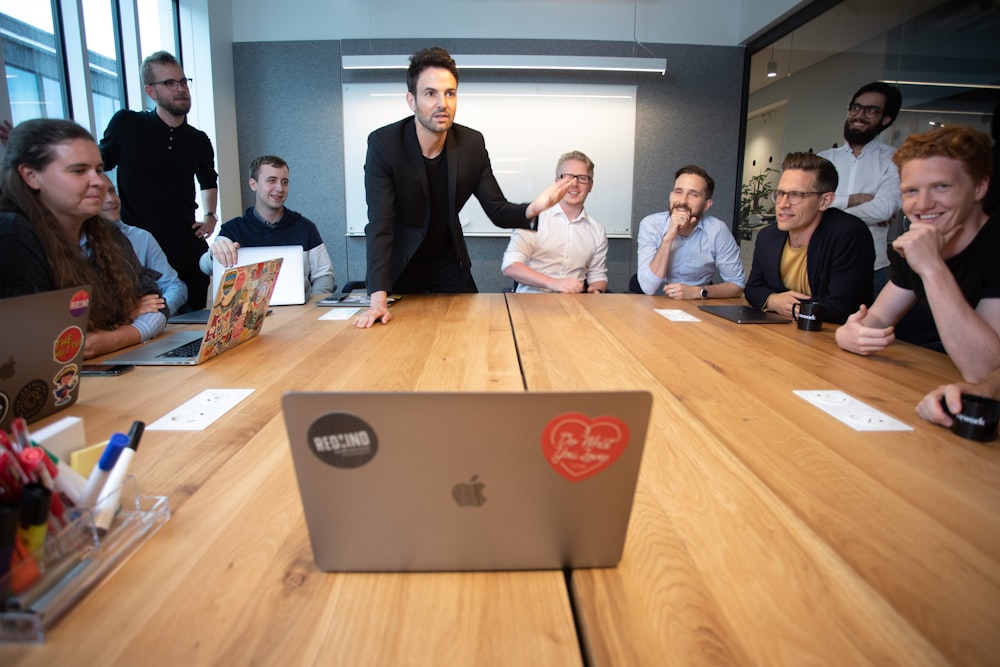 a group of people sitting around a wooden table