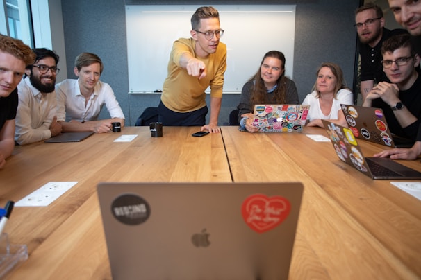 a group of people sitting around a wooden table