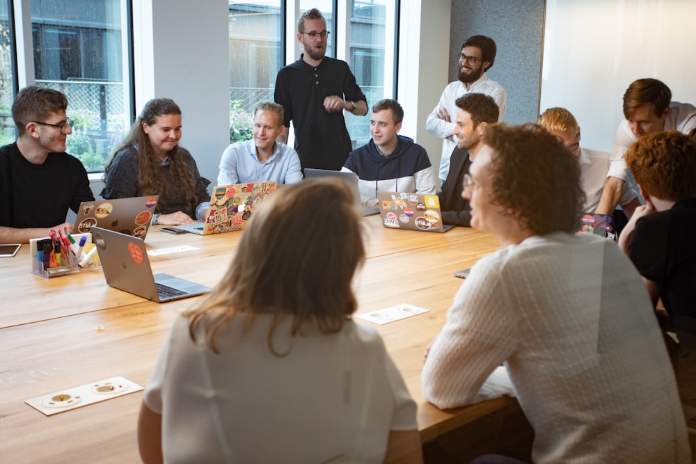 a group of people sitting around a wooden table