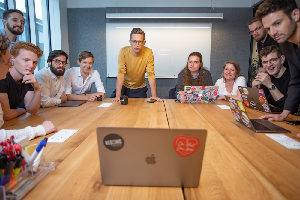 a group of people sitting around a wooden table