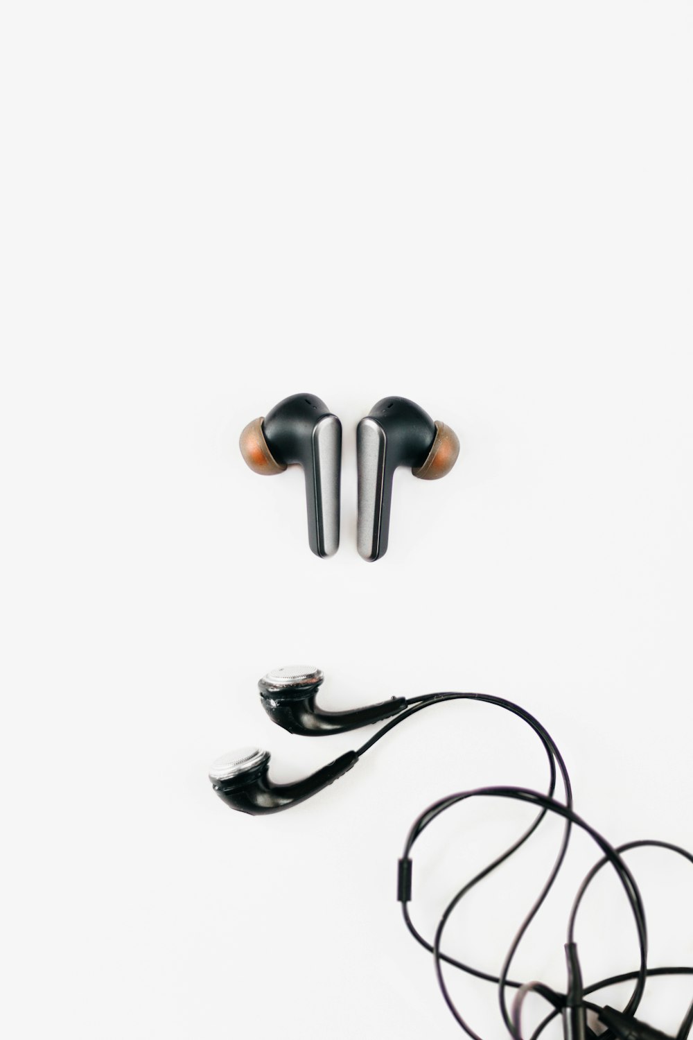 a pair of black earphones sitting on top of a white surface