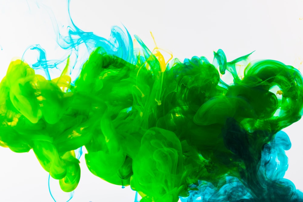 a mixture of green and blue ink in water