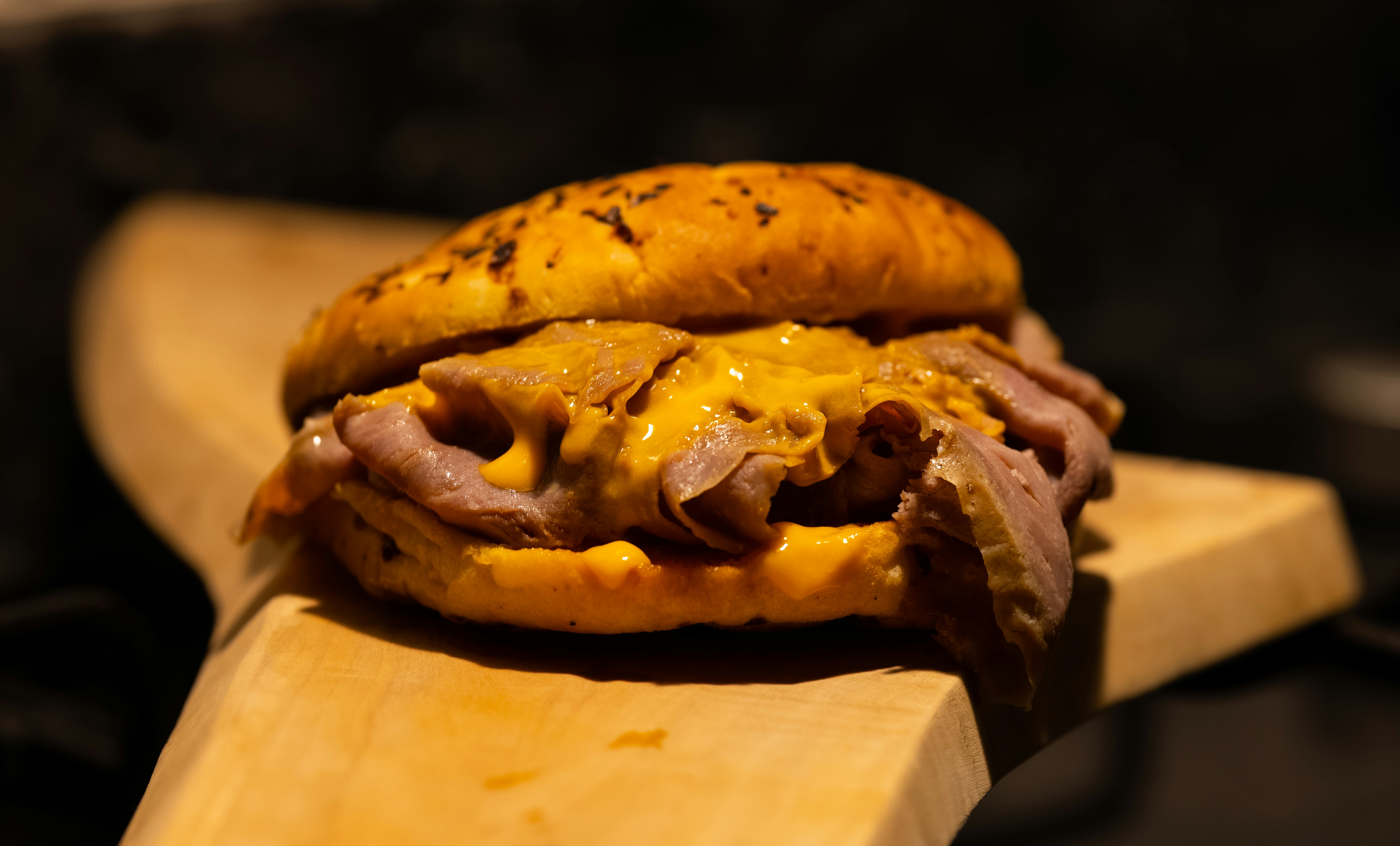 a ham and cheese sandwich sitting on a cutting board