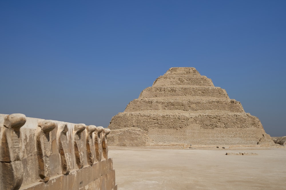 uma pirâmide muito alta sentada no meio de um deserto
