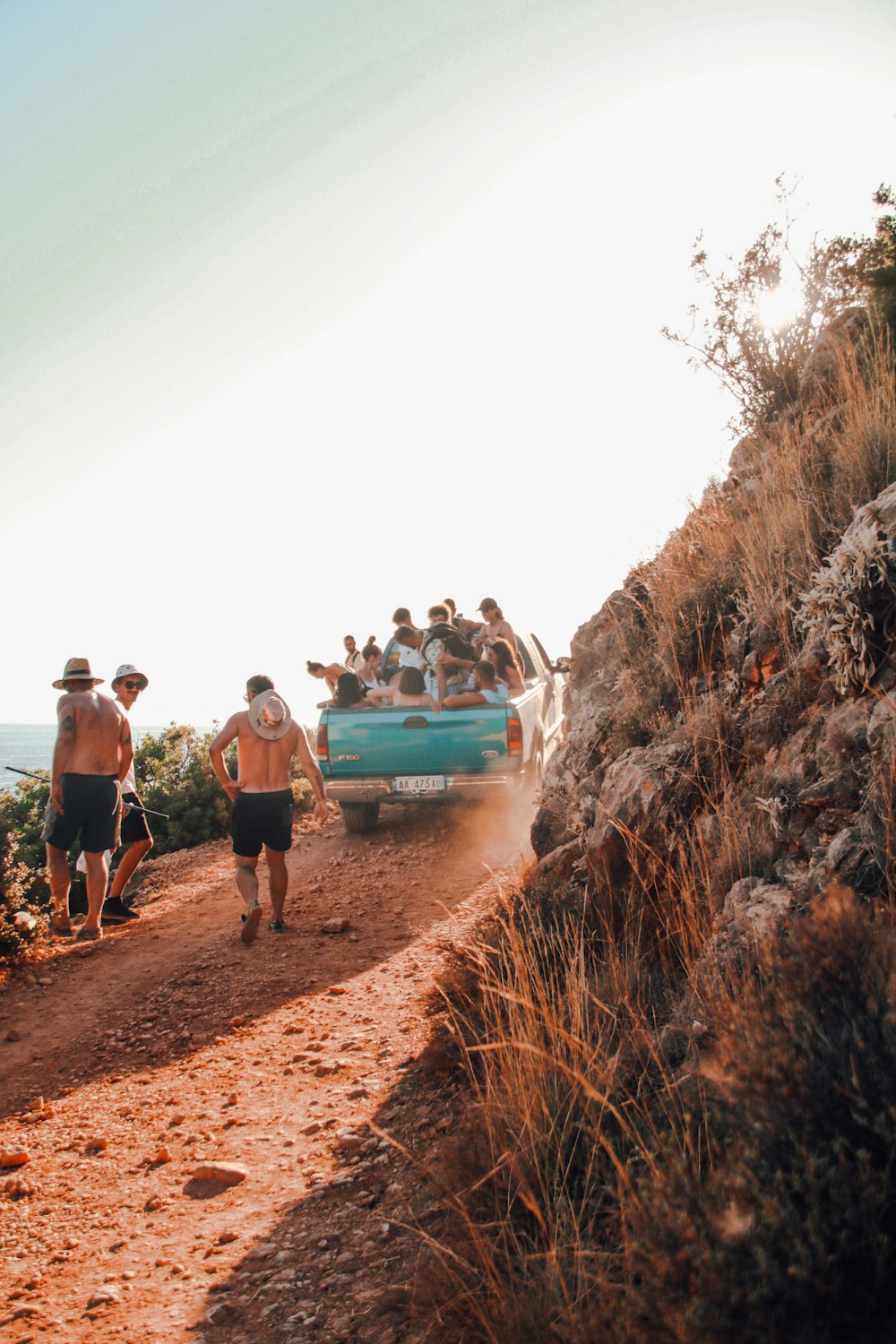 a group of people riding on the back of a blue truck