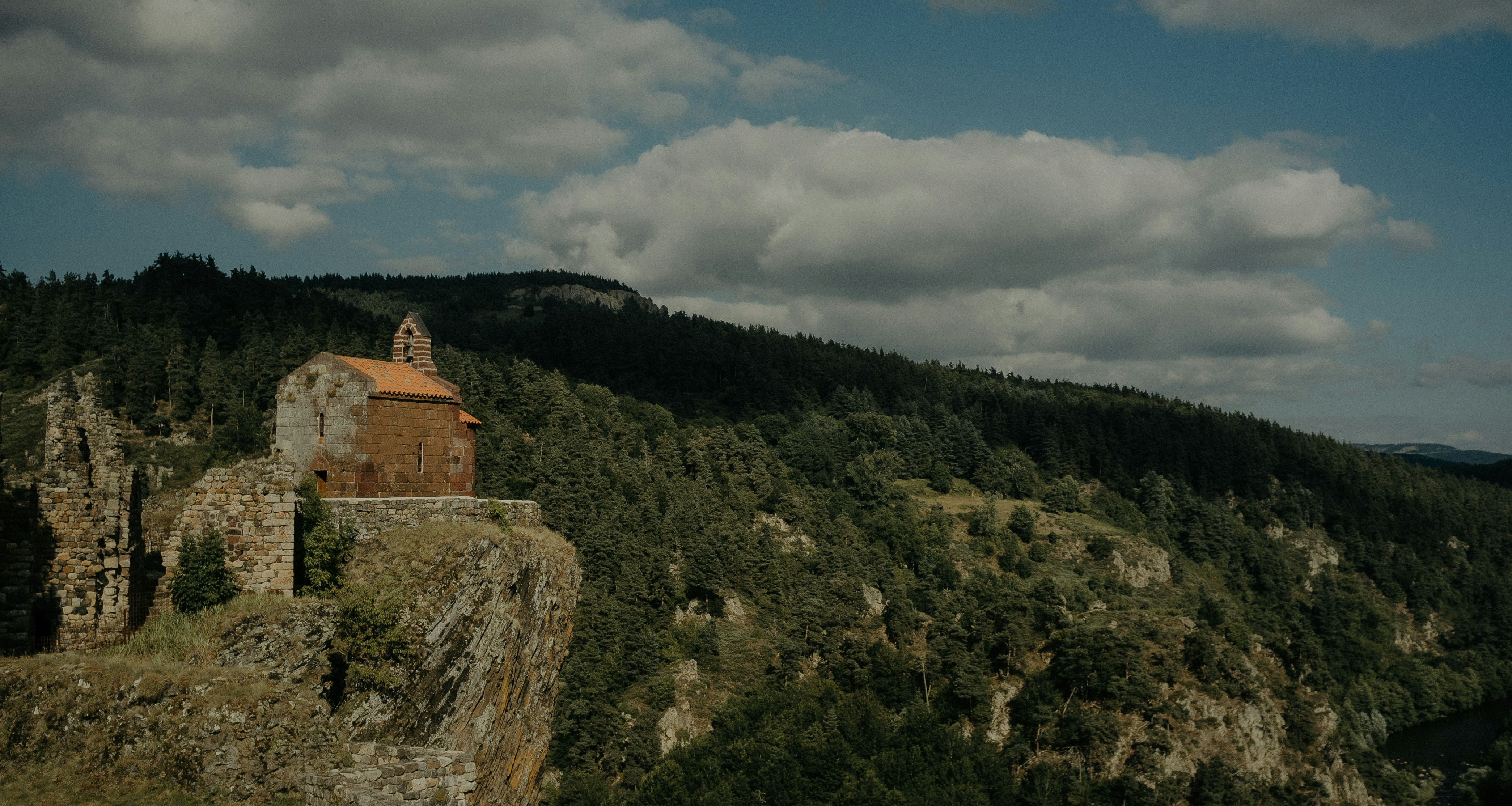 a castle on a cliff with a mountain in the background