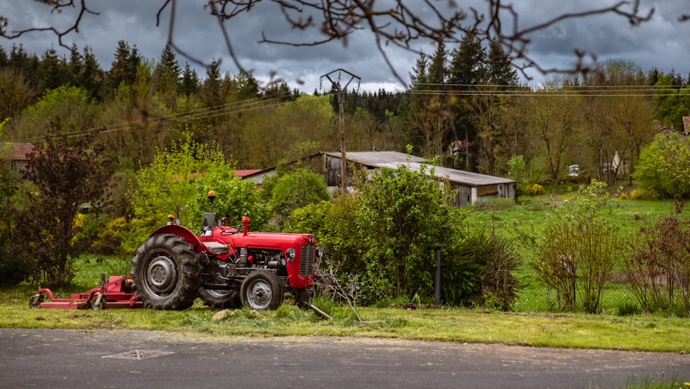 a red tractor parked on the side of a road