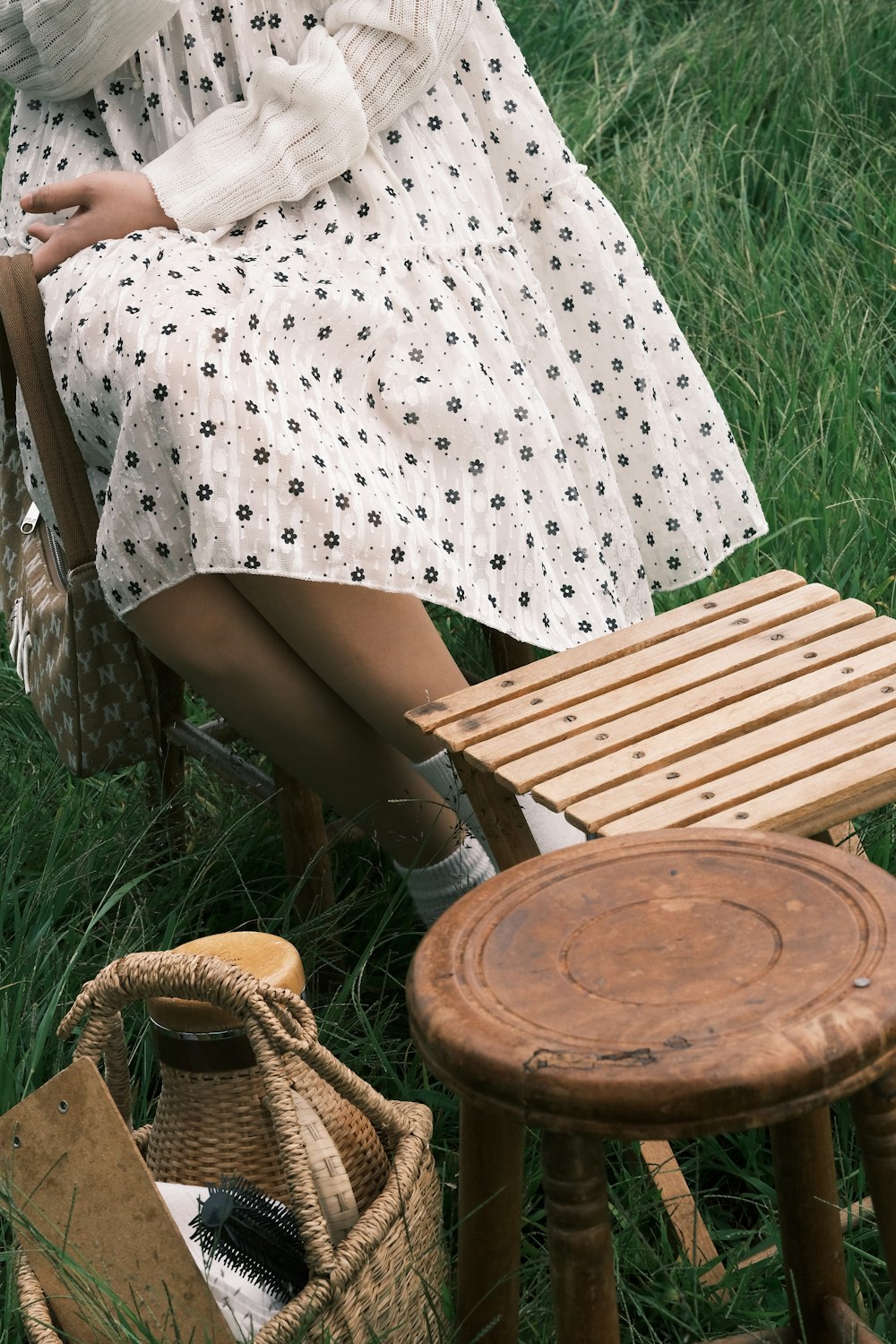 a woman sitting in a chair next to a wooden stool