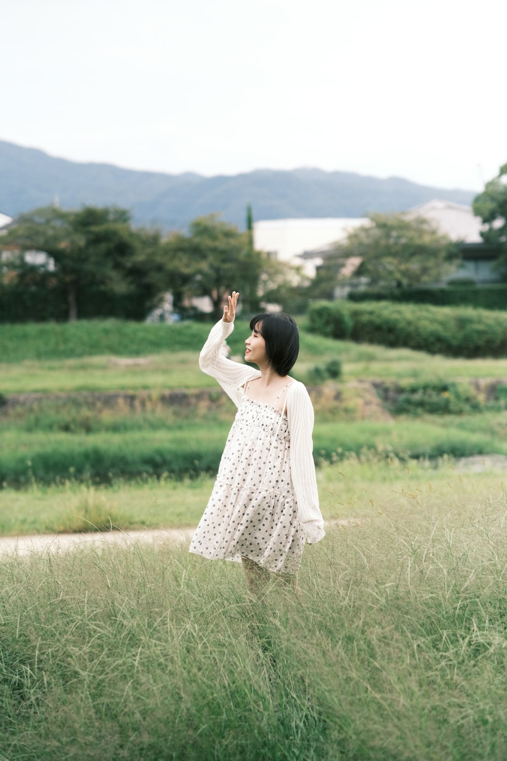 a woman in a white dress standing in a field