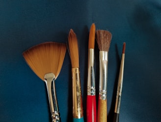 a group of brushes sitting on top of a blue surface