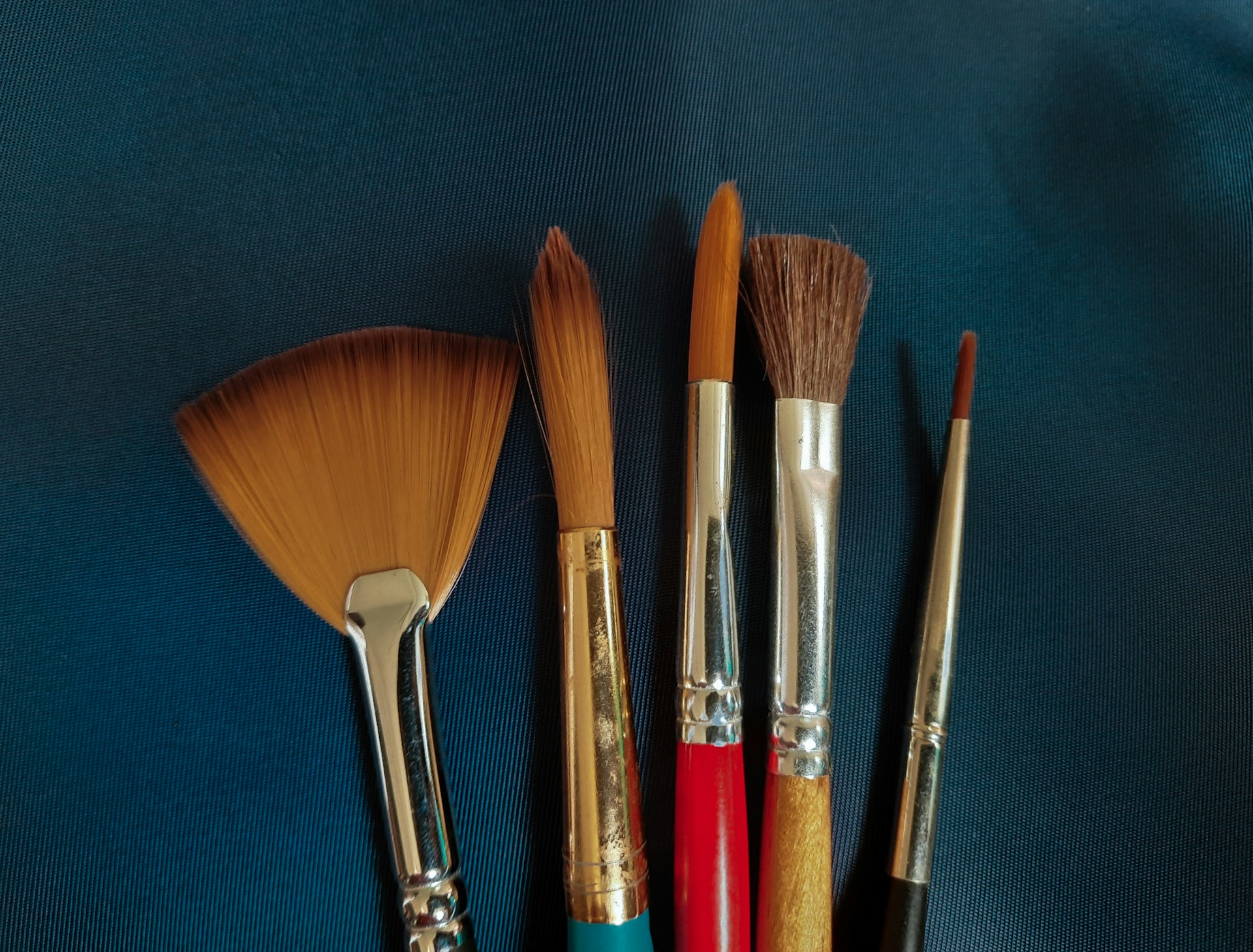 a group of brushes sitting on top of a blue surface