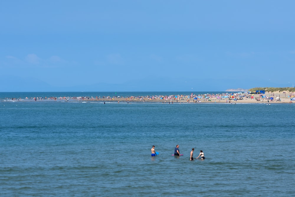 a group of people standing in the ocean