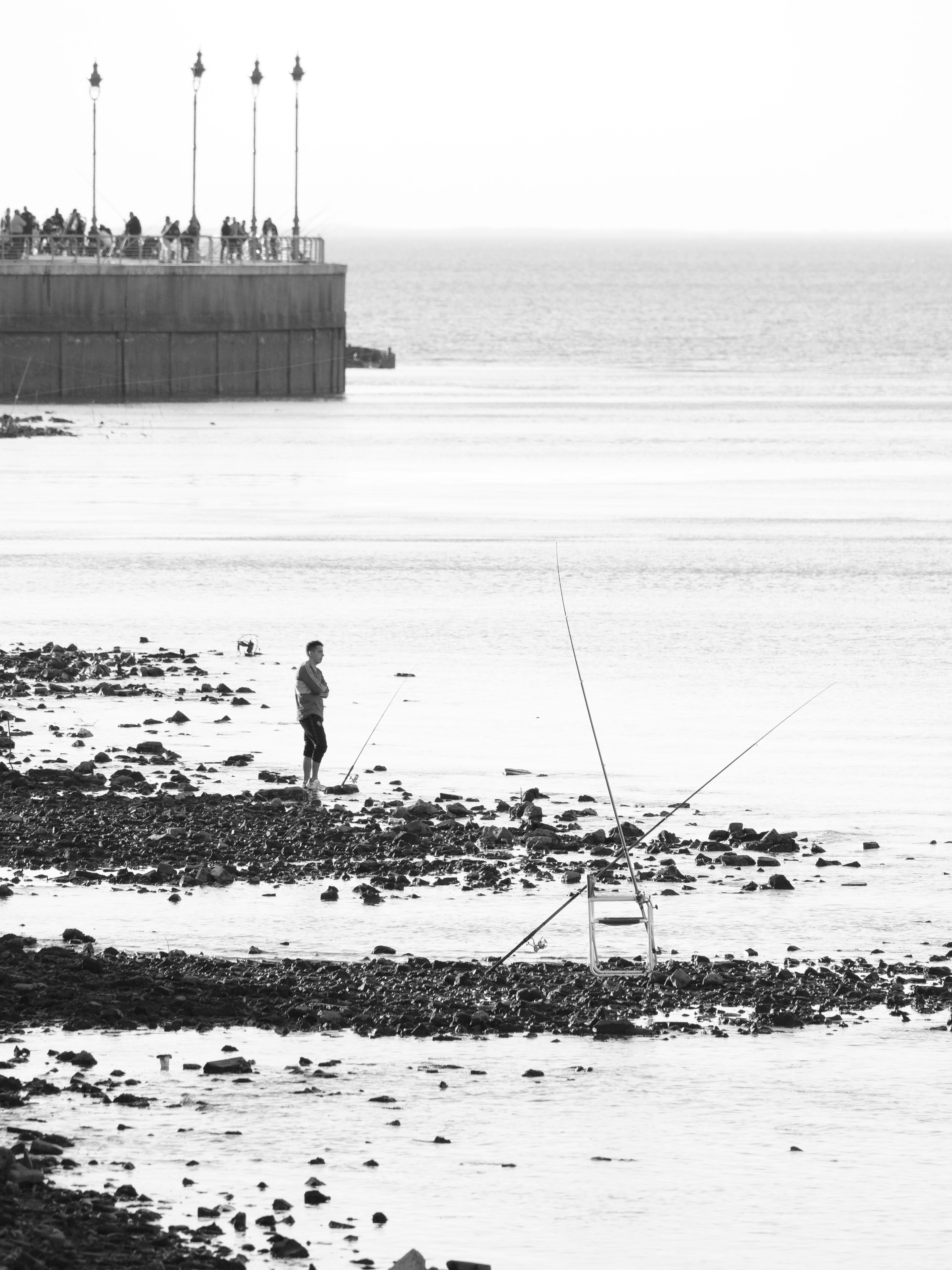 a man standing on top of a beach next to a body of water