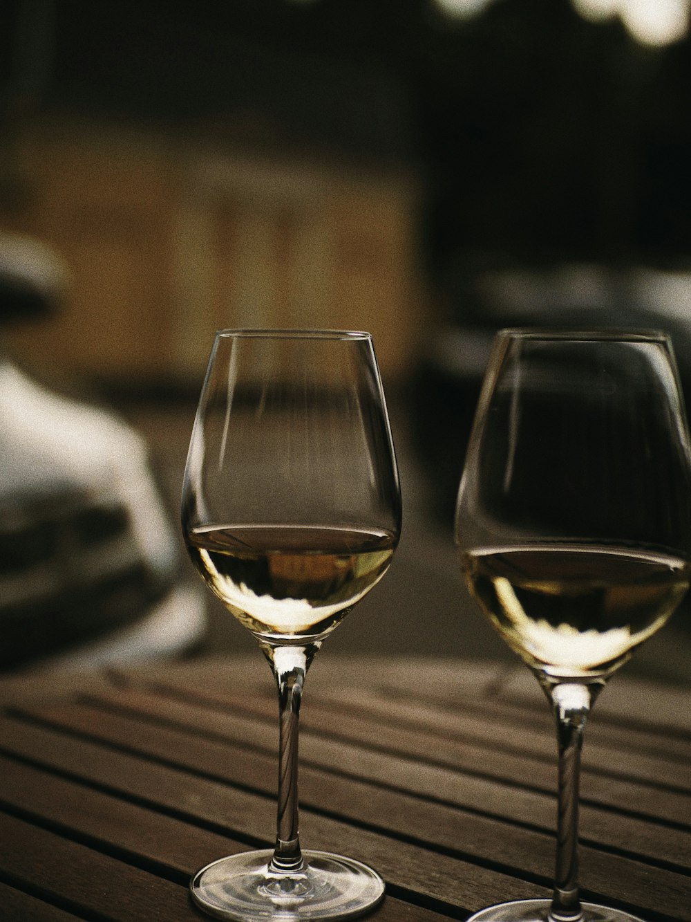 two wine glasses sitting on top of a wooden table