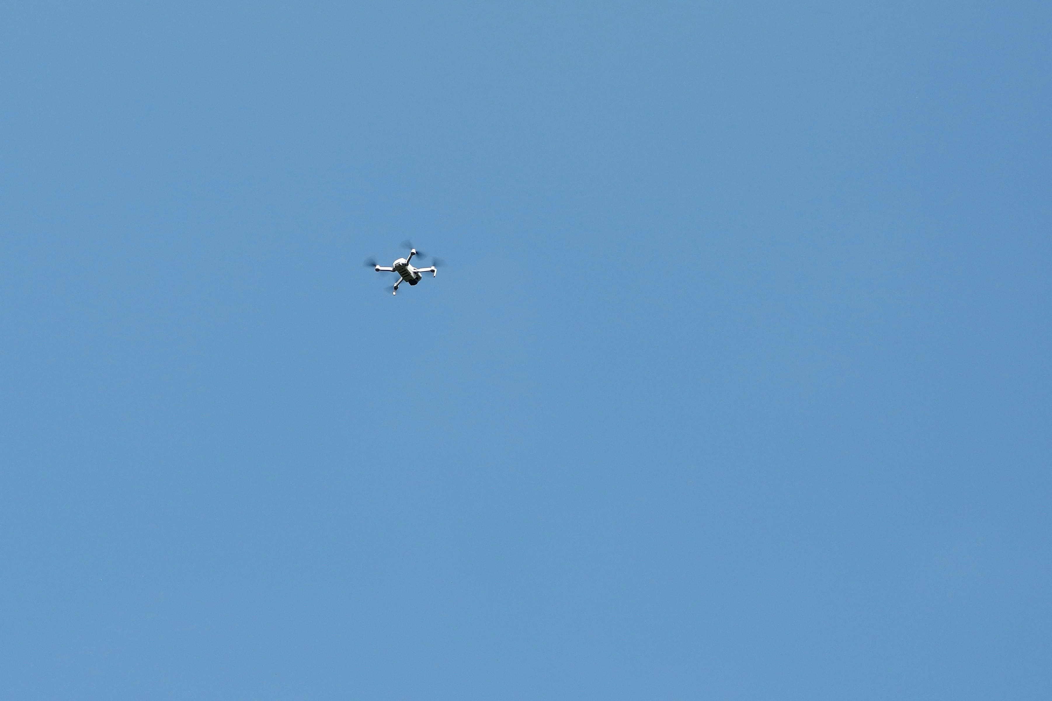 a small airplane flying through a blue sky