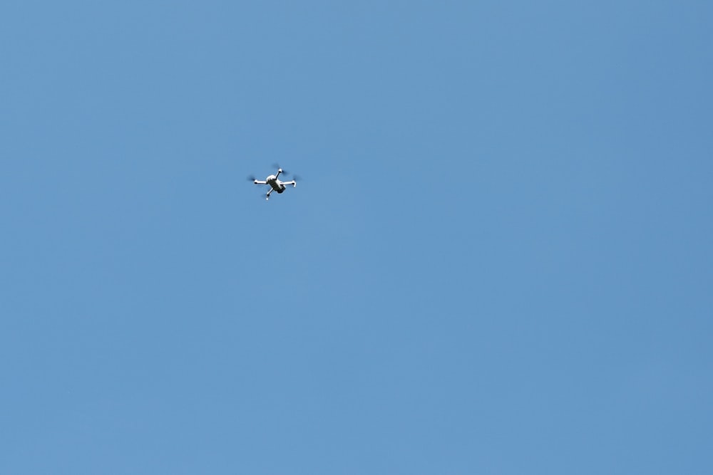 a small airplane flying through a blue sky