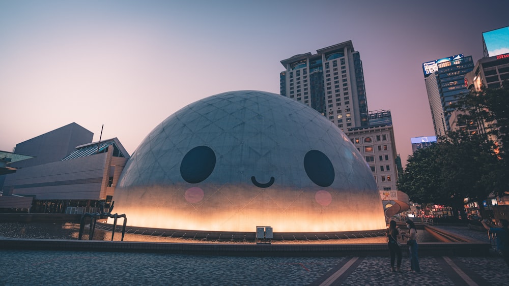 a large dome with a face on it in the middle of a city