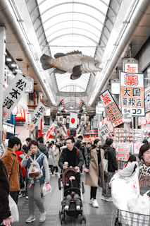 A bustling scene at Kuromon Market in Osaka, with fresh seafood and vibrant local produce on display.