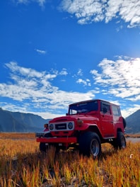A sturdy Toyota Hilux pickup truck parked outside the Antares Rent a Car workshop under a bright sky.