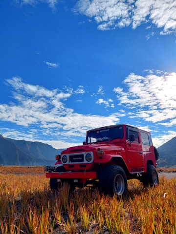 A sturdy Toyota Hilux pickup truck parked outside the Antares Rent a Car workshop under a bright sky.
