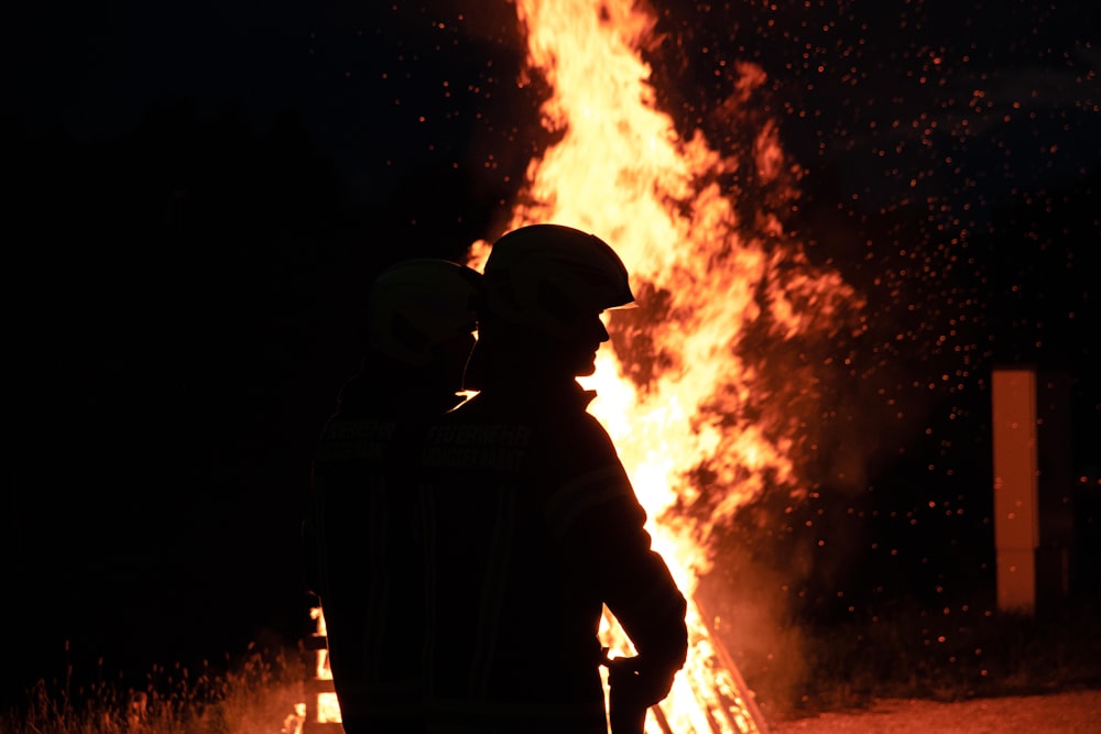 a firefighter standing in front of a large fire