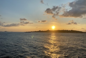 Sunset view from a luxury boat deck with warm golden light reflecting on the sea.