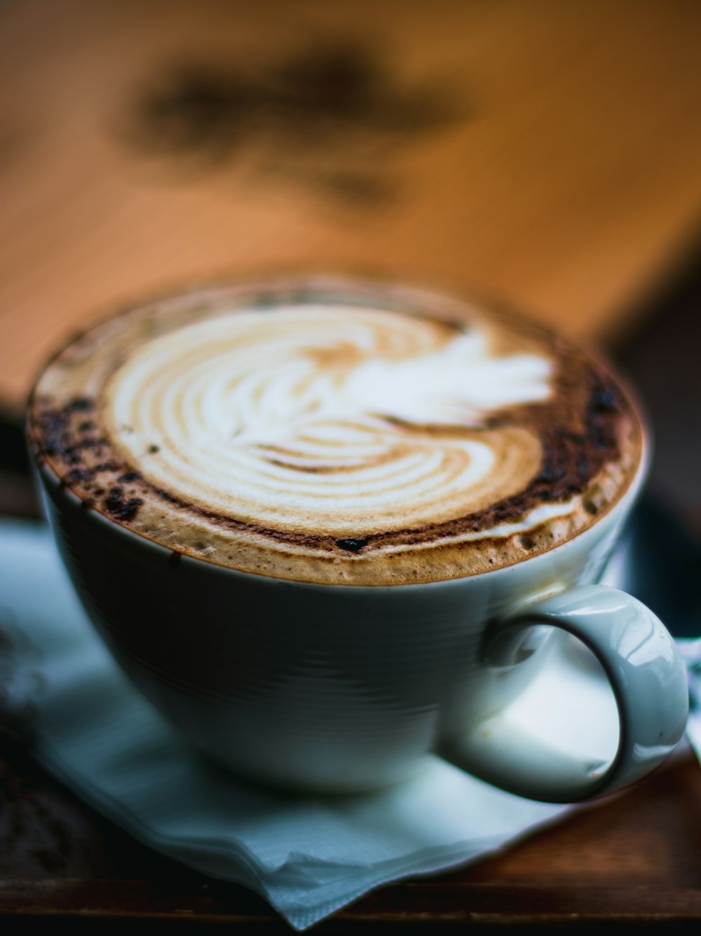 a cappuccino is sitting on a napkin on a table