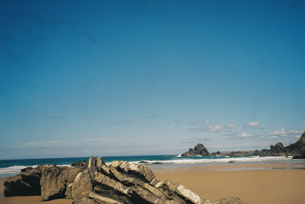 uma prancha de surf está deitada em uma rocha na praia