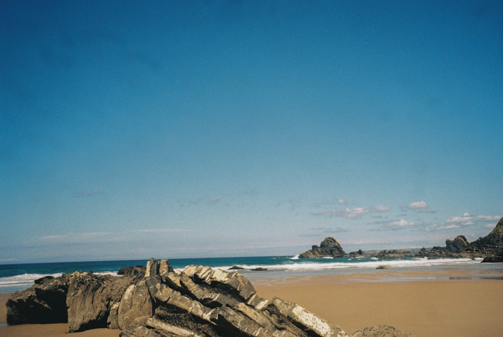 a surfboard is laying on a rock on the beach