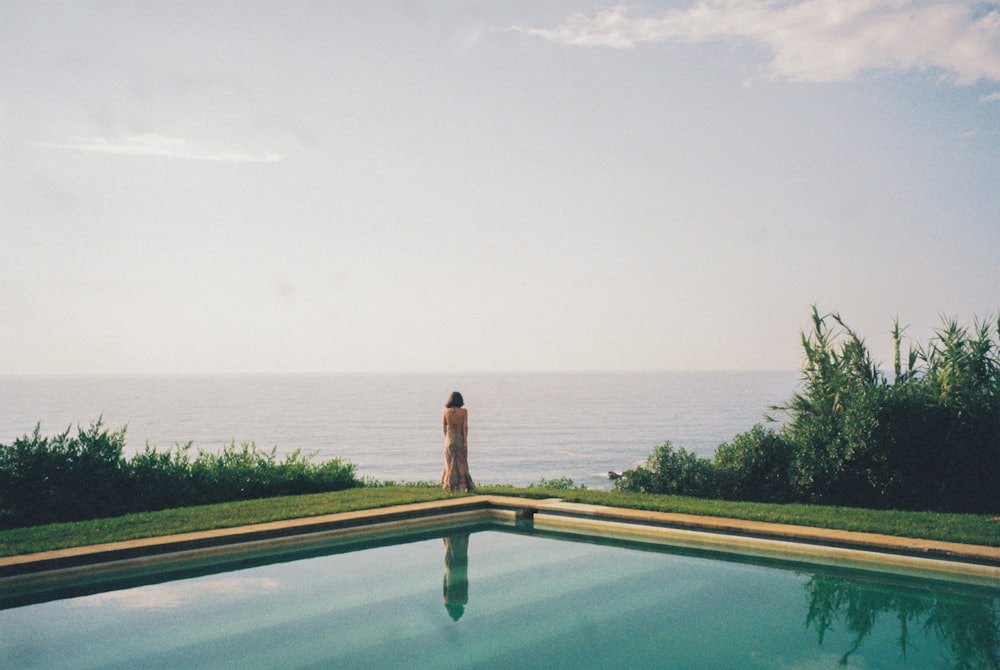 a person standing on the edge of a swimming pool