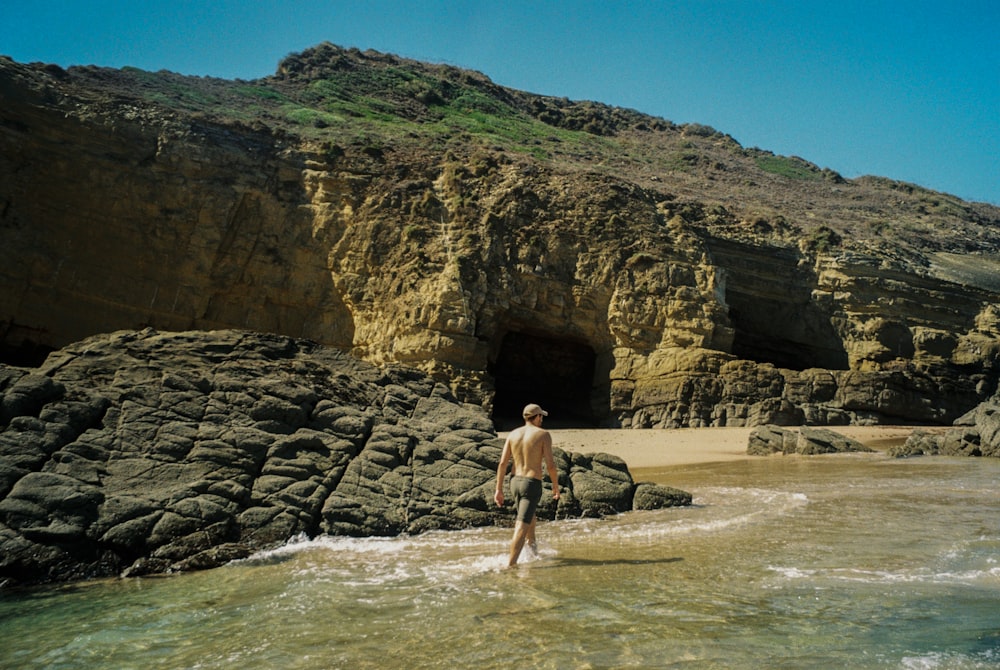 a man wading into the water at the beach