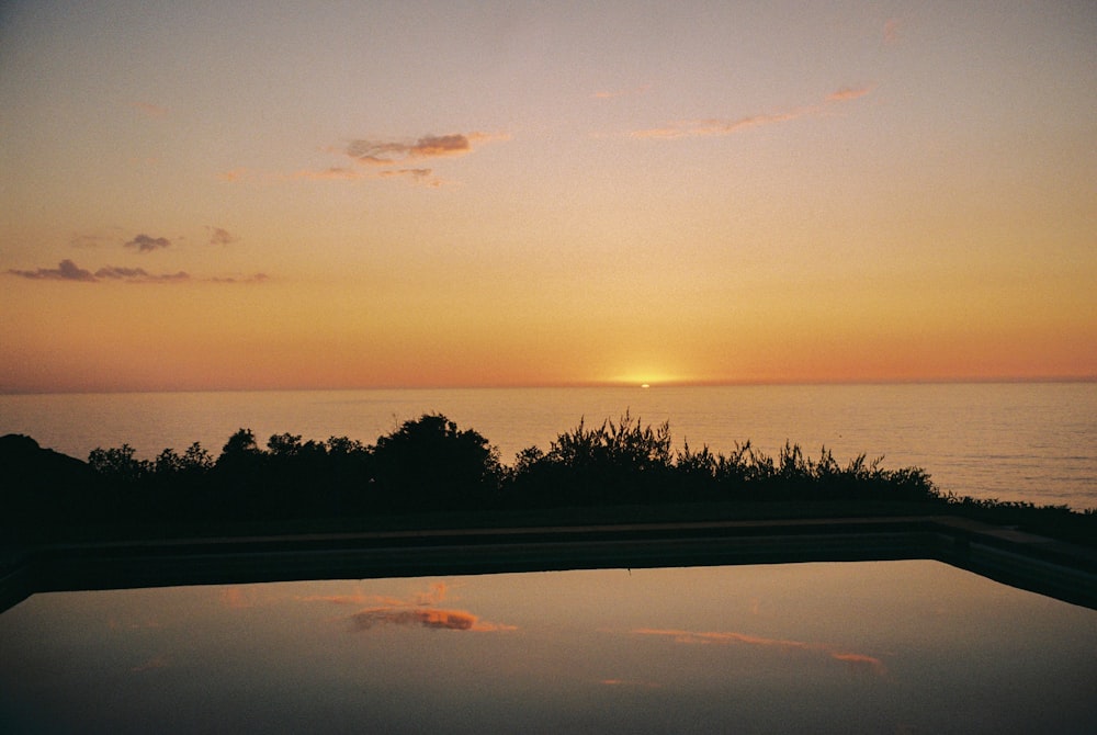 the sun is setting over a body of water